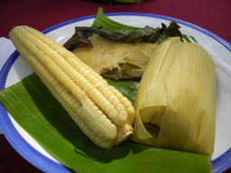 Cob corn, sweet corn bread and corn tamale served on a banana leaf